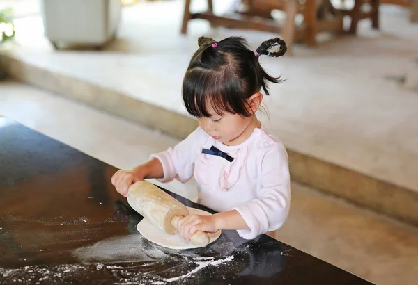 Słodkie dziewczynki za pomocą drewnianym wałkiem na ciasto do pizzy. W domu proces przygotowania pizzy. — Zdjęcie stockowe