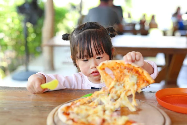 Kis gyermek lány élvezze pizzát eszik. — Stock Fotó