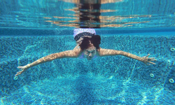 Foto subaquática de uma jovem mulher mergulhando na piscina . — Fotografia de Stock