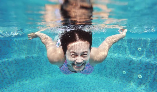 Inyección submarina de una joven que se sumerge en la piscina . — Foto de Stock
