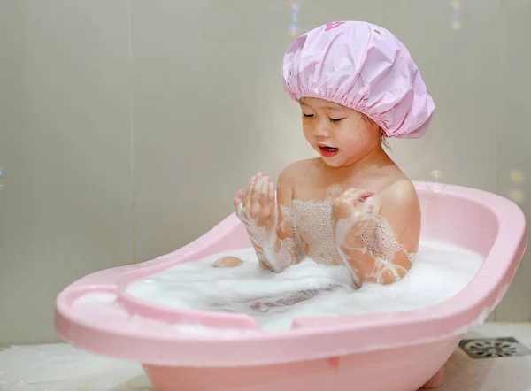 Счастливый маленький ребенок в колпачке пены в ванне — стоковое фото