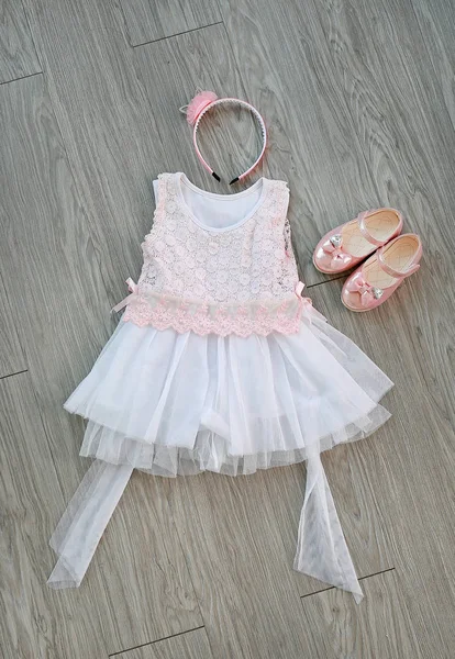 Růžová Bílé Krajkové Šaty Dívčí Malé Boty Čelenka Dřevěné Pozadí — Stock fotografie