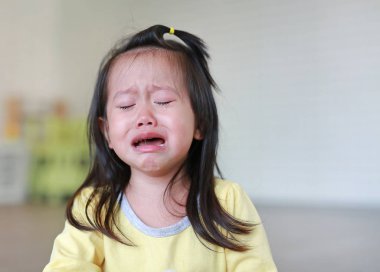 Küçük çocuk kızı ile ağlayan yakın yüzünde ağlamaklı.