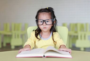 Çocuk odası bir kitap okuma zeki küçük çocuk kız gözlük tasarlamak.