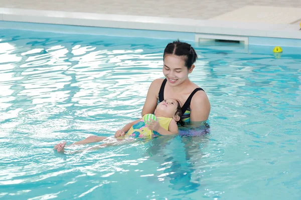 Close up mother teaching kid in swimming pool