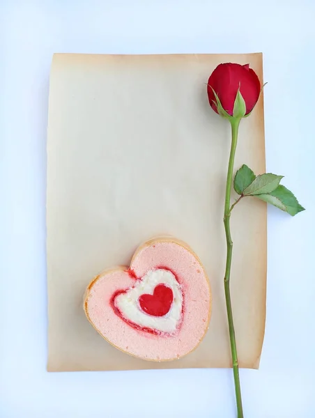 Red roses flower and petals with heart jam roll on old brown paper