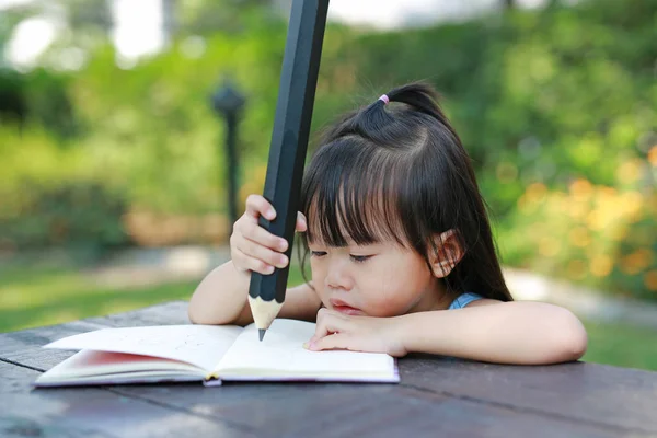 庭の教育コンセプト の表に書く子少女 — ストック写真