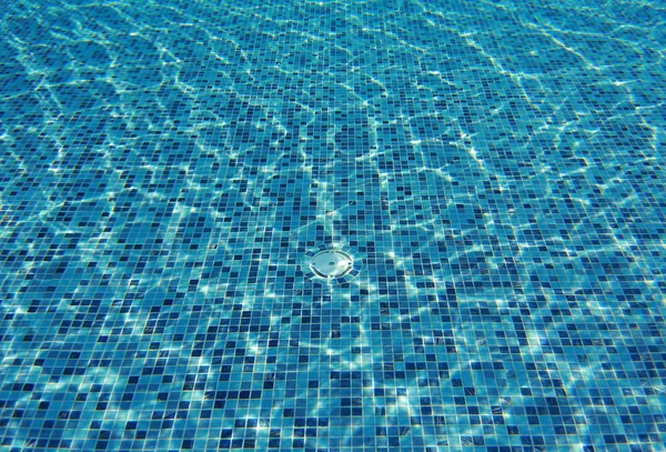 Water wave in swimming pool with light reflecting. Texture background.