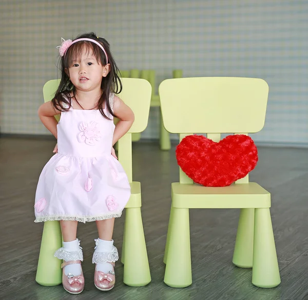 Menina Bonito Vestido Rosa Sentado Cadeira Com Travesseiro Coração Vermelho — Fotografia de Stock