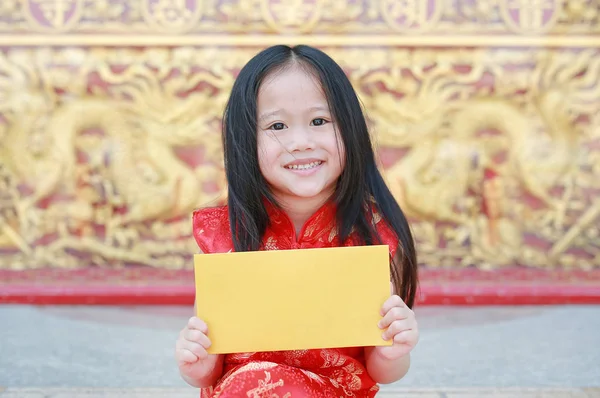 Happy chinese new year festival. smiling little Asian girl holding gold envelope.