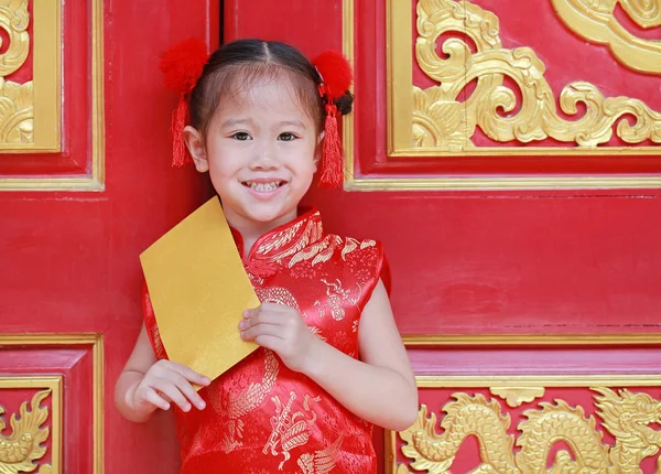 Happy chinese new year festival. smiling little Asian girl holding gold envelope.