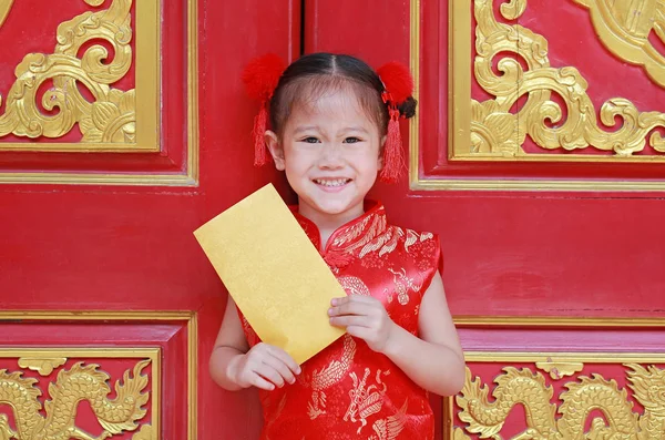 Happy chinese new year festival. smiling little Asian girl holding gold envelope.