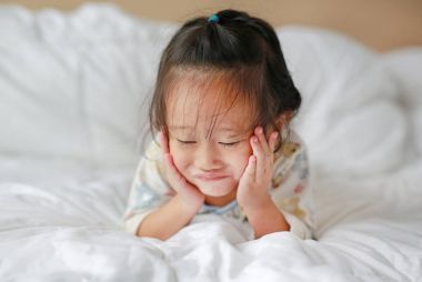 Sevimli küçük kız yatakta yatarken sabah