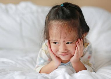 Sevimli küçük kız yatakta yatarken sabah