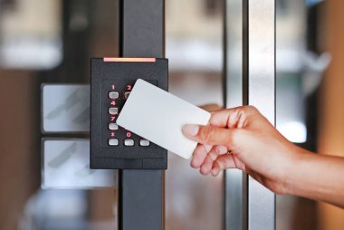 Kapı erişim denetimi - kilit ve kapı kilidini açmak için bir anahtar kart tutan genç kadın.