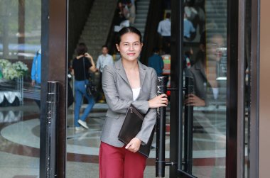 Güzel genç iş kadını açık kapı ve dışında yürüyüş.