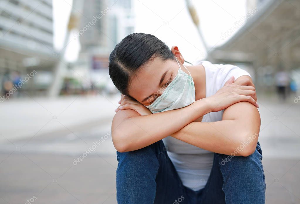 Woman wearing protective mask to protect pollution and the flu at public area.