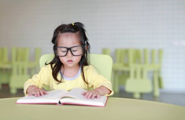Çocuk odası bir kitap okuma zeki küçük çocuk kız gözlük tasarlamak.
