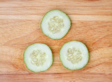 Üstten Görünüm salatalık dilimleri ahşap blok beyaz arka plan üzerinde