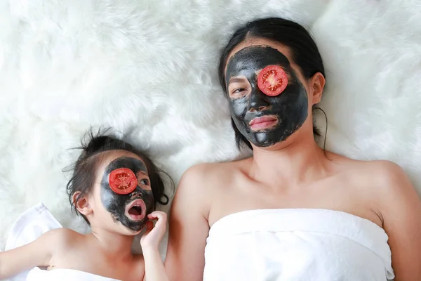 Junge Frau Und Kind Kohlepeelender Gesichtsmaske Mit Geschnittenen Tomaten Auf — Stockfoto