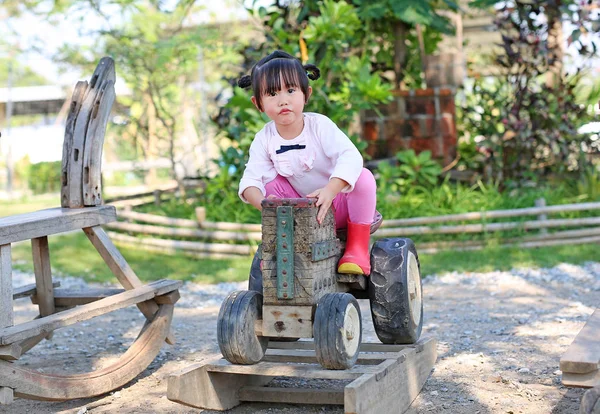 Menina Pequena Montando Velho Trator Brinquedo Madeira Jardim — Fotografia de Stock