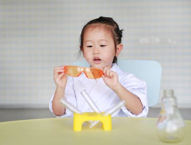 Asyalı çocuk bilim adamı üniforma, bilim adamı kimya ve eğitim kavramı.