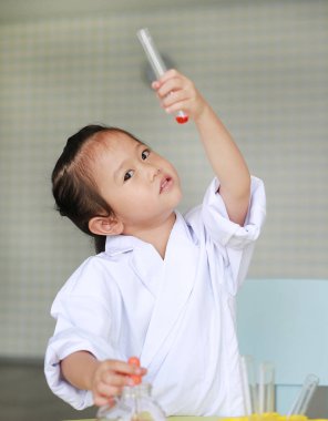 Asyalı çocuk bilim adamı Tekdüzen holding tüp sıvı, bilim adamı kimya ve eğitim kavramı ile.