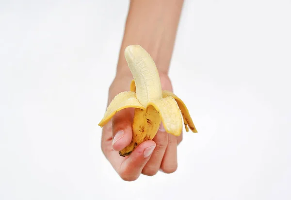 白い背景の上の皮バナナを持っている手 — ストック写真