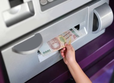 Child hand receive money from ATM clipart