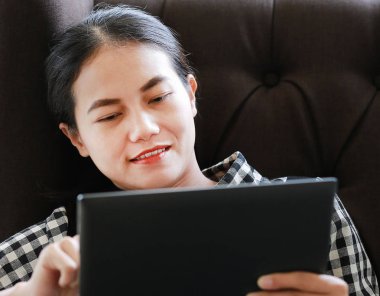 Yakın çekim genç Asyalı kadın tablet kütüphanede kullanma.