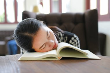 Genç Asyalı kadın dinlenmek ve kütüphanede uyku.