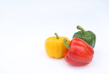 Beyaz arka plan üzerinde izole yeşil, kırmızı ve sarı dolmalık biber.