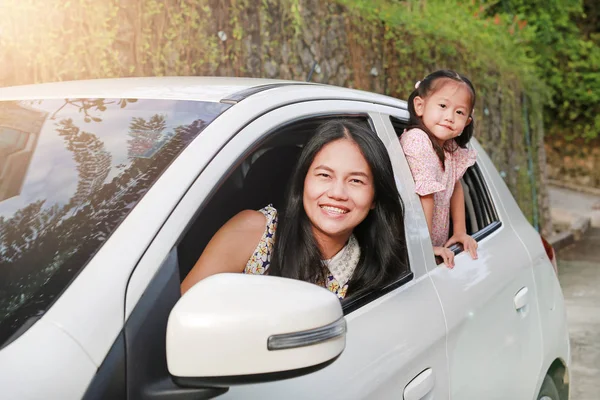 快乐的年轻女子和她的小女孩坐在后座 家庭旅行概念 — 图库照片