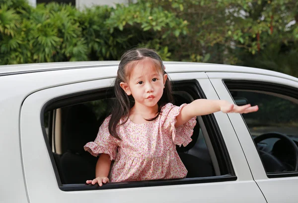 微笑的小亚洲孩子看着窗外的汽车 — 图库照片