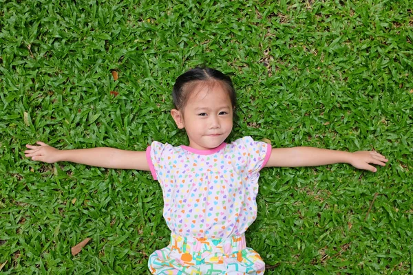 Lächelnd Kleines Glückliches Asiatisches Mädchen Entspannt Sich Auf Grünem Gras — Stockfoto