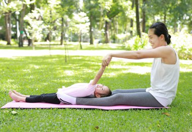 Anne ve kızı bahçede egzersiz yaparak