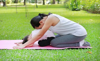 Anne ve kızı bahçede egzersiz yaparak