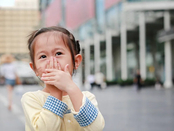 Liten Asiatisk Tjej Som Täcker Munnen Och Näsan Med Händerna — Stockfoto