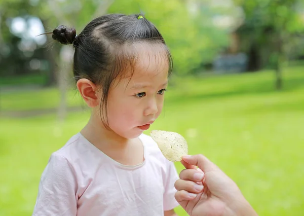 孩子女孩吃土豆片由母亲手在庭院里 — 图库照片