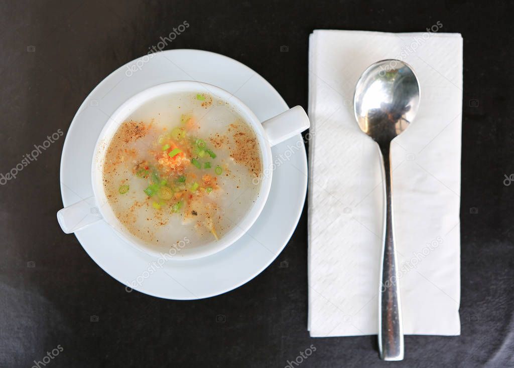 Traditional Thailand porridge rice gruel in cup with spoon and tissue. Top view.