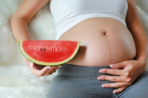 Gravid Kvinna Sitter Soffan Och Hålla Skivad Vattenmelon Magen — Stockfoto