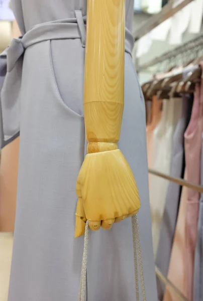 Hand of wooden doll holding rope of shopping bag