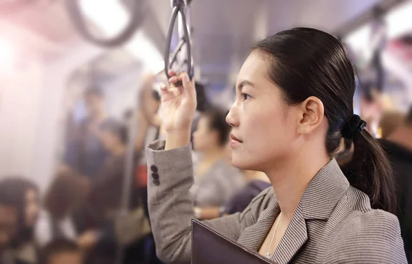 Young asian woman inside BTS (Bangkok Mass Transit System), the public transportation in Bangkok, Thailand.