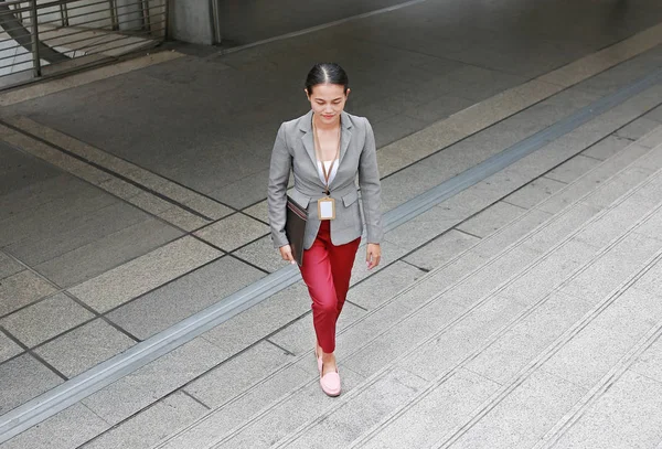 Beautiful young business woman walking outside. Asian businesswoman office worker in downtown business district.