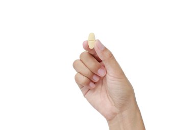 Beyaz arka plan üzerinde izole sarı hap tutan el