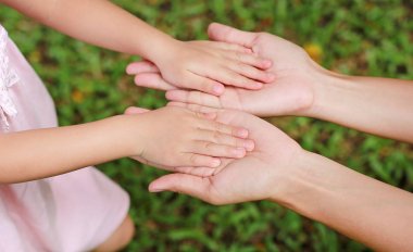 Anne ve kız birbirlerine tutan elleri. arka planda yaz park