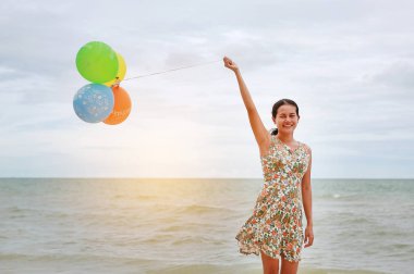 Balon tatilde kumsalda tutan mutlu kadın. Tatil kavramı.