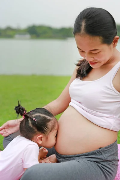 Criança Beijando Barriga Mulher Grávida Contra Fundo Verde — Fotografia de Stock