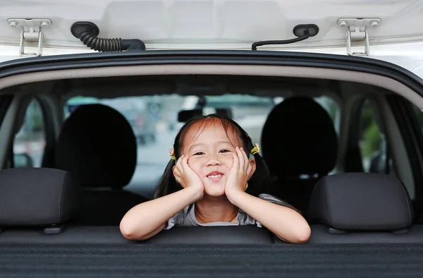幸福的亚洲儿童女孩躺在汽车的掀背门 — 图库照片