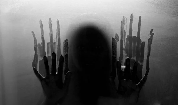 person shadows on Frosted glass - violence concept background. Black and white.